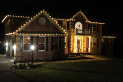 Ellicott City holiday lighting display — warm white roofline and pillar lighting creating a cozy, welcoming glow.