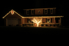 Sykesville holiday lighting installation — warm white roofline lights and a wrapped tree for a classic, elegant look.