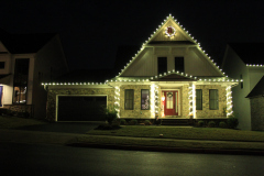 Roofline lights and wreaths creating a bright, cheerful holiday atmosphere.
