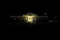 Warm white roofline and pillar lighting creating a cozy, welcoming glow.